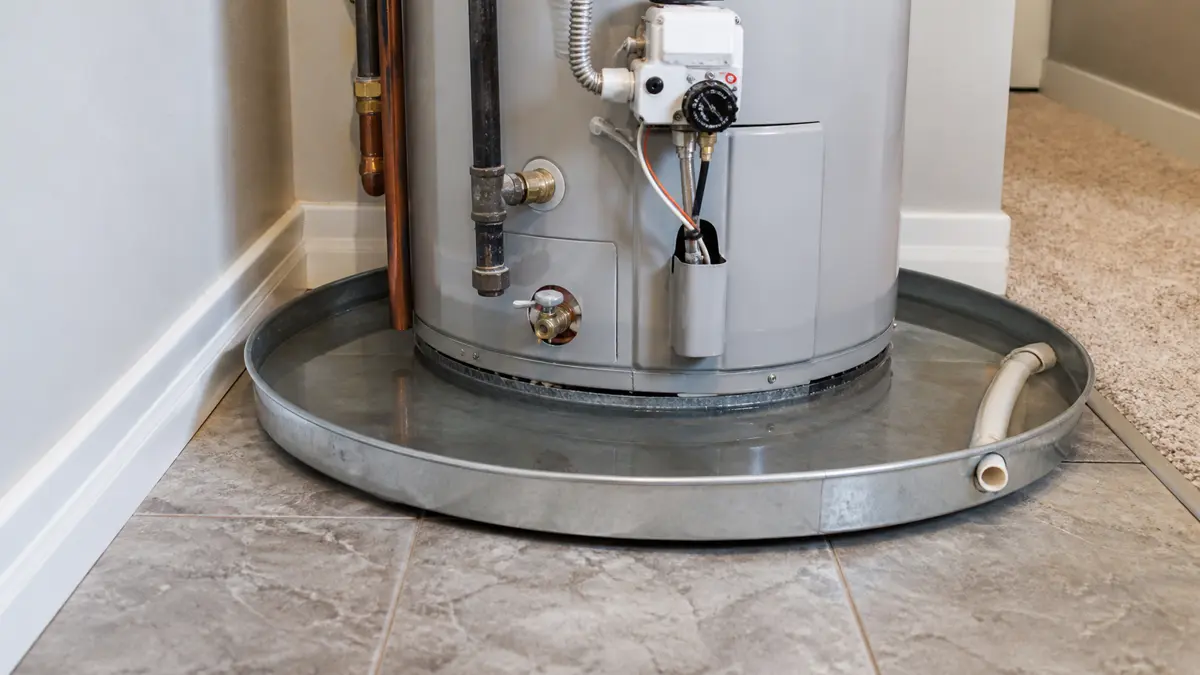 Water visible in a drain pan below a residential water heater